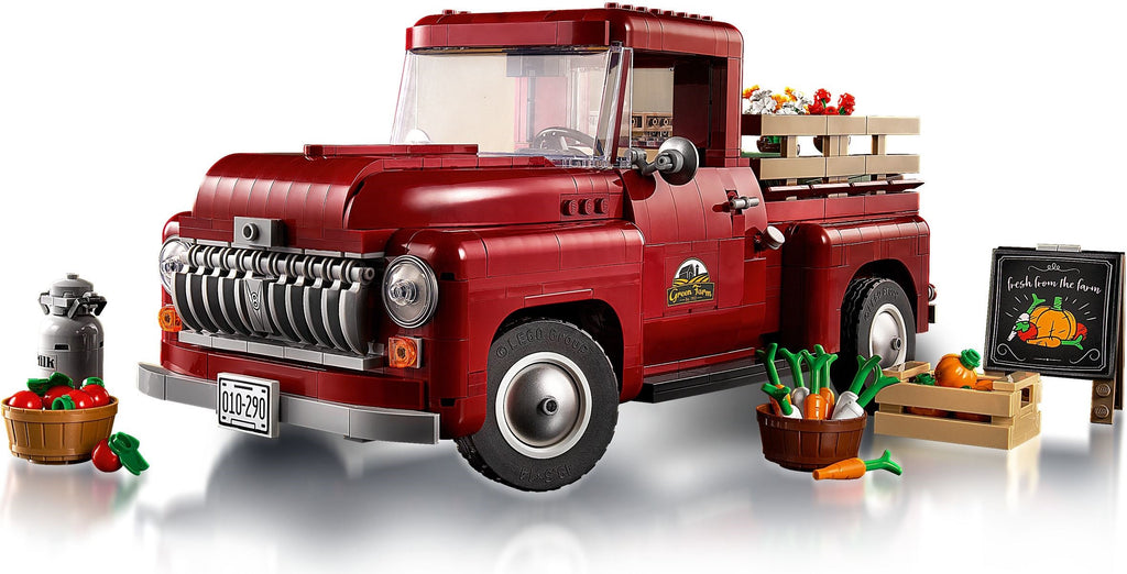 Red toy truck with a cargo bed filled with vegetables on a white background