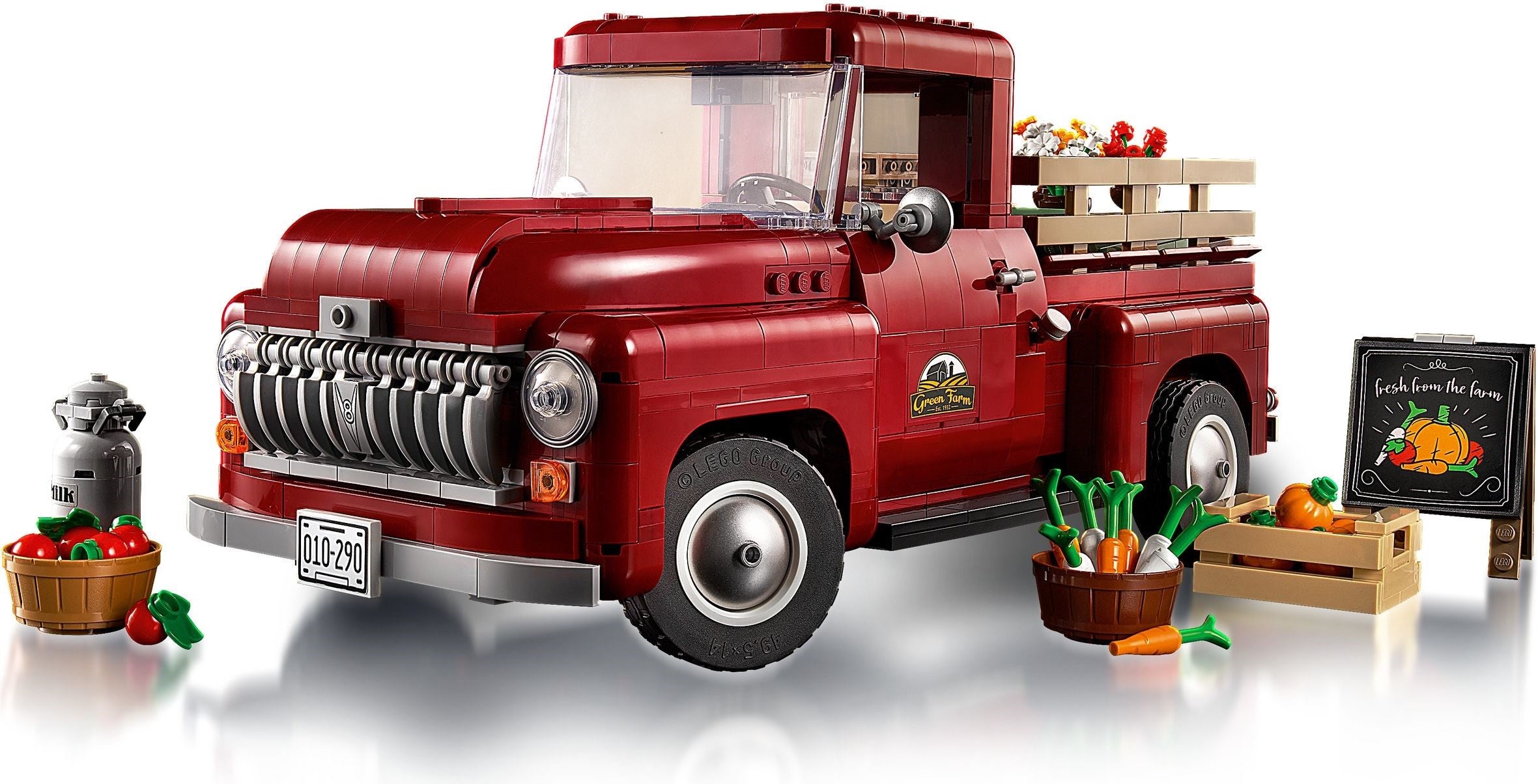 Red toy truck with a cargo bed filled with vegetables on a white background