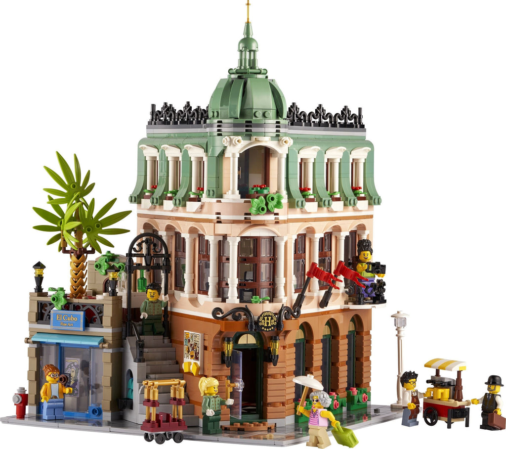Detailed LEGO model of a building with people and palm tree on a white background
